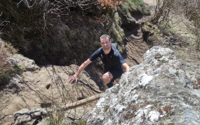 Participant courant sur un sentier de trail dans les Volcans d'Auvergne.